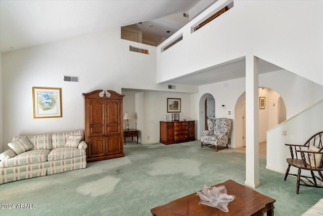 carpeted living room featuring a high ceiling