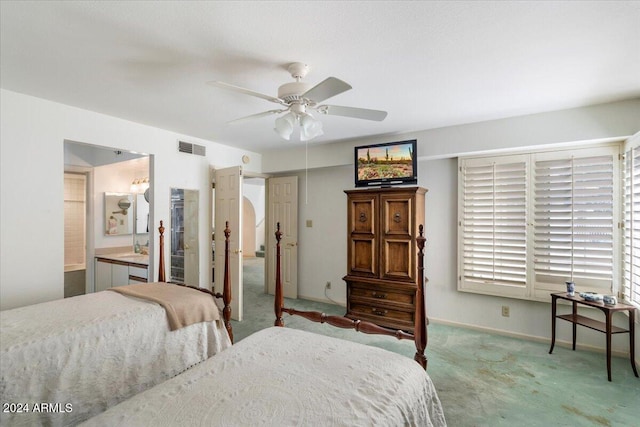 bedroom featuring ceiling fan, light colored carpet, ensuite bath, and sink