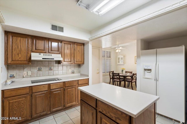 kitchen featuring ceiling fan, light tile patterned flooring, backsplash, black electric stovetop, and white fridge with ice dispenser