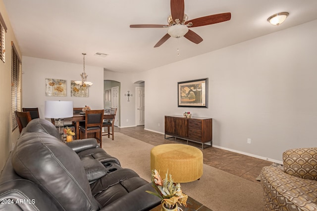 tiled living room with ceiling fan with notable chandelier