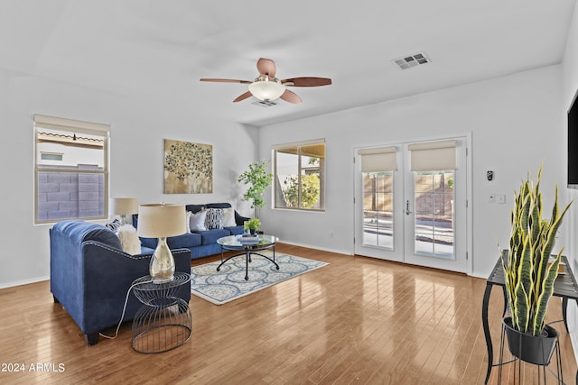 living room featuring wood finished floors, baseboards, visible vents, a ceiling fan, and french doors