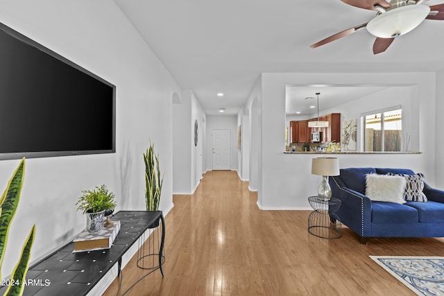 hallway featuring recessed lighting, light wood-style flooring, and baseboards