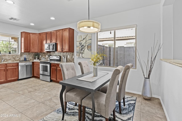 kitchen with recessed lighting, decorative backsplash, light tile patterned floors, stainless steel appliances, and a sink