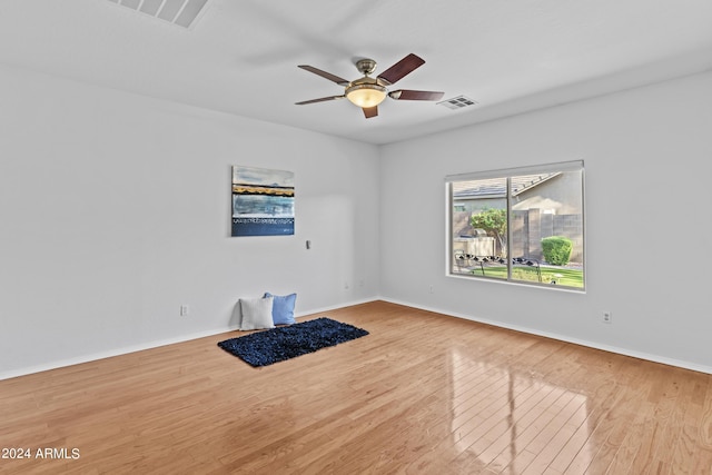 spare room featuring wood finished floors, visible vents, and a ceiling fan