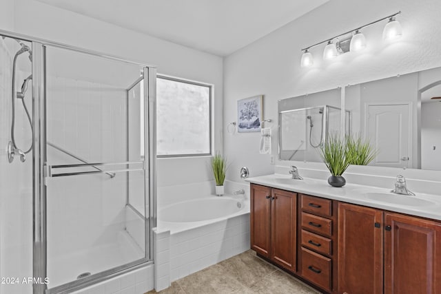 bathroom featuring double vanity, a shower stall, a bath, and a sink