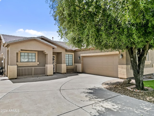 view of front of home with driveway, a garage, stucco siding, and a tiled roof