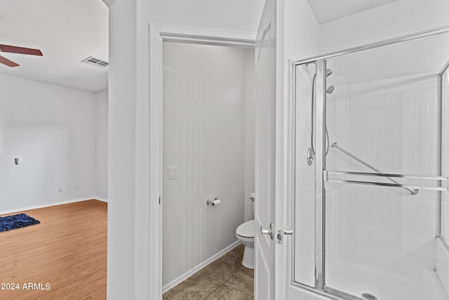 full bath featuring visible vents, toilet, a ceiling fan, and a stall shower