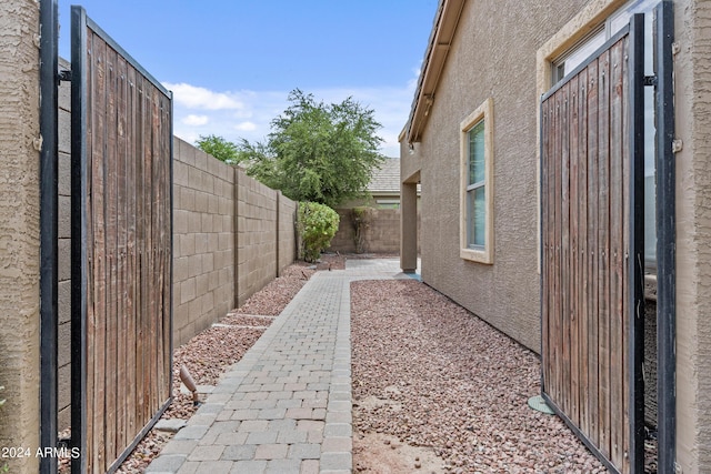 view of side of property with stucco siding, a patio, and a fenced backyard