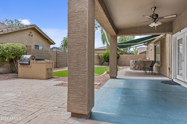 view of patio / terrace featuring ceiling fan, a fenced backyard, area for grilling, and exterior kitchen