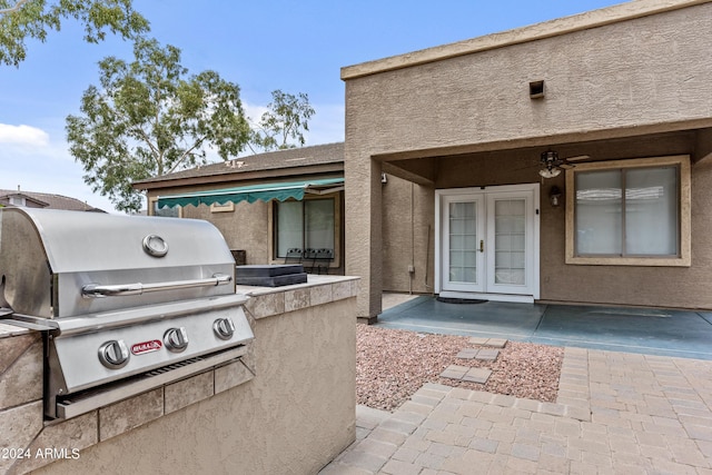 view of patio / terrace with a grill, french doors, ceiling fan, and exterior kitchen