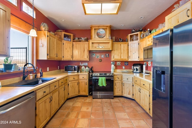 kitchen featuring a healthy amount of sunlight, sink, pendant lighting, and appliances with stainless steel finishes