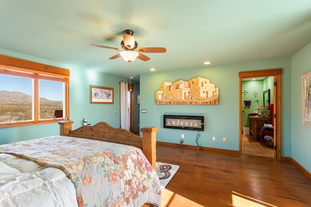 bedroom featuring a mountain view, dark hardwood / wood-style floors, and ceiling fan