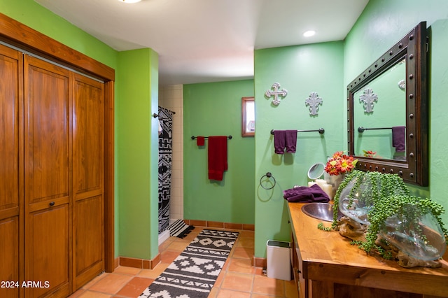 bathroom with vanity, tile patterned flooring, and a tile shower