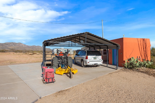 view of vehicle parking with a carport and a mountain view