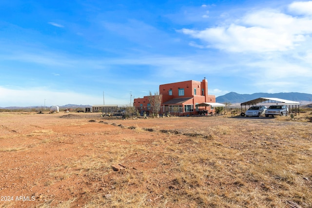 exterior space with a mountain view, a rural view, and a carport