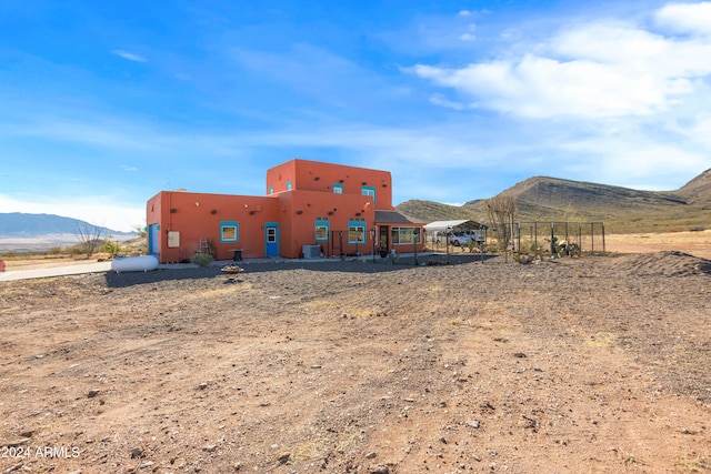 rear view of house featuring cooling unit and a mountain view