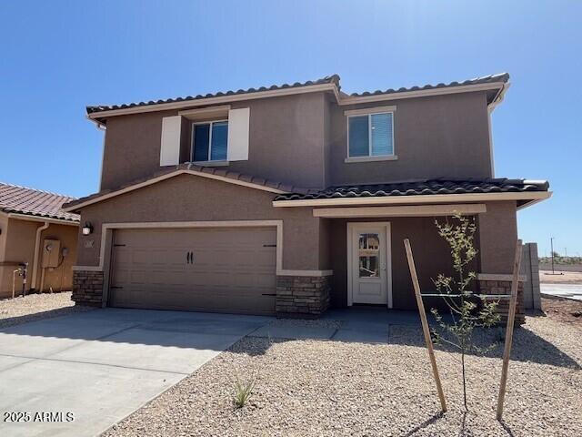 1057 W W Virginia Ave, Florence, AZ 85132 - view of front of house with driveway, stone siding, a garage, and stucco siding