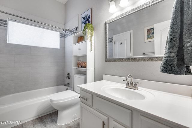 full bathroom with tiled shower / bath combo, vanity, hardwood / wood-style flooring, and toilet