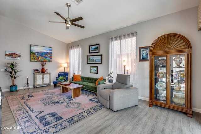 living room featuring ceiling fan, light wood-type flooring, and vaulted ceiling