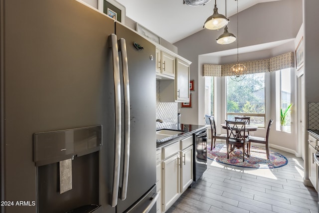 kitchen with tasteful backsplash, stainless steel fridge, hanging light fixtures, vaulted ceiling, and dark wood-type flooring