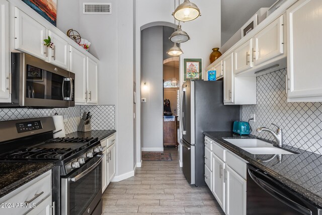 kitchen featuring stainless steel appliances, light hardwood / wood-style floors, white cabinets, and sink