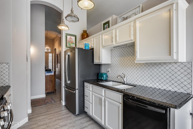 kitchen with appliances with stainless steel finishes, decorative light fixtures, sink, light hardwood / wood-style floors, and white cabinets