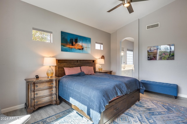 bedroom with connected bathroom, multiple windows, vaulted ceiling, and ceiling fan