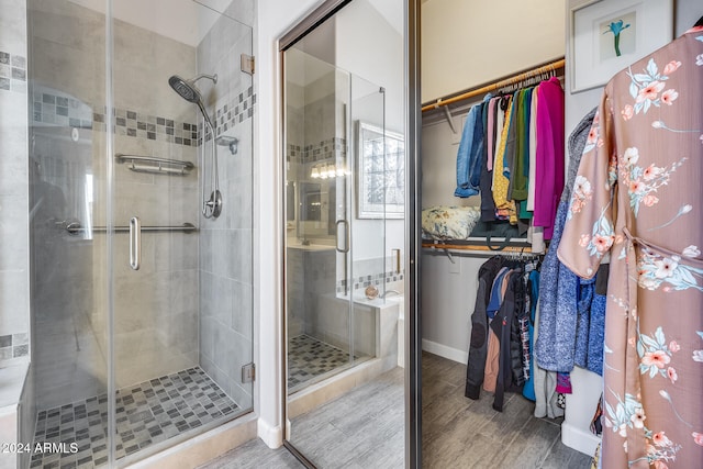 bathroom featuring wood-type flooring and a shower with door