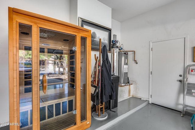 doorway to outside with electric water heater and concrete flooring