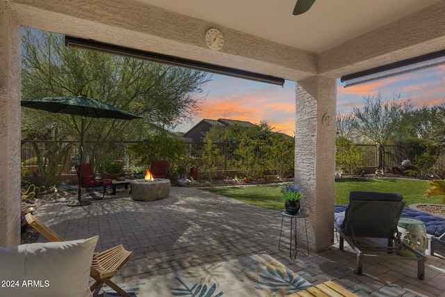 patio terrace at dusk with a yard and an outdoor fire pit