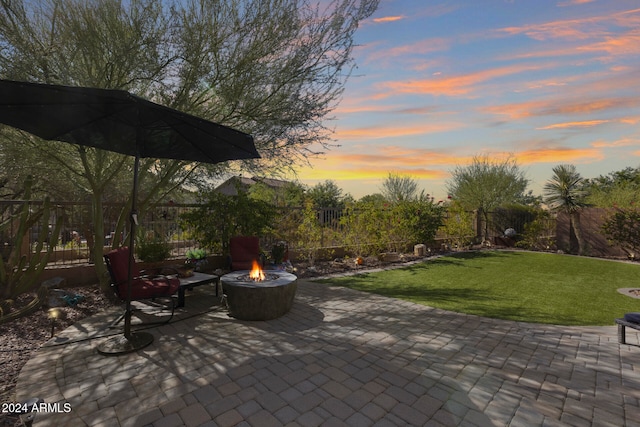 patio terrace at dusk with a yard and an outdoor fire pit