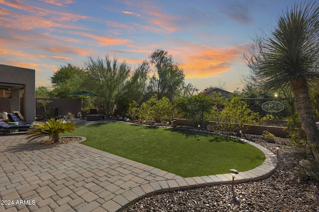 yard at dusk featuring a patio area