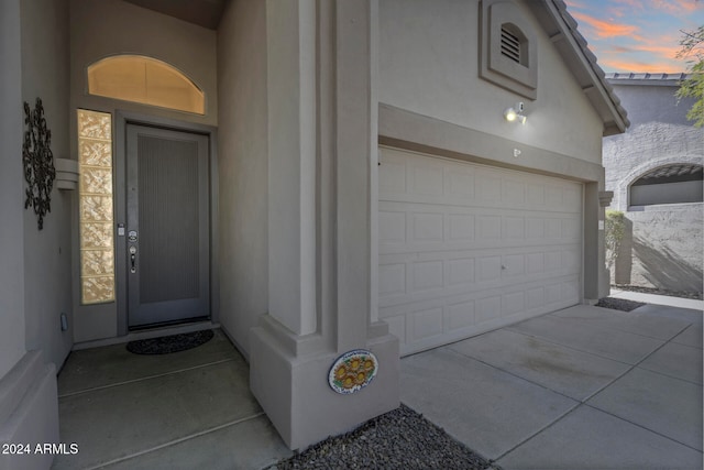 exterior entry at dusk with a garage