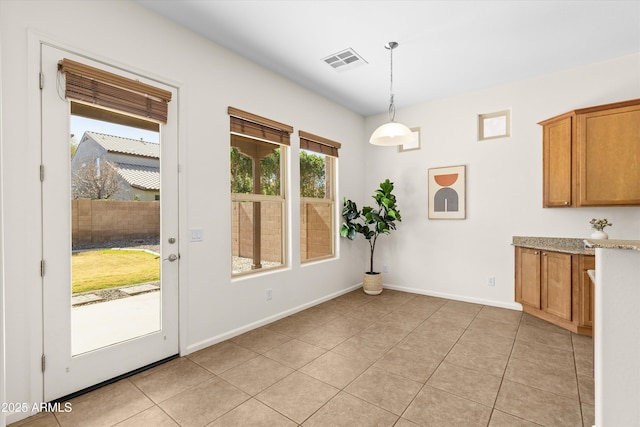 unfurnished dining area with light tile patterned floors, visible vents, and baseboards