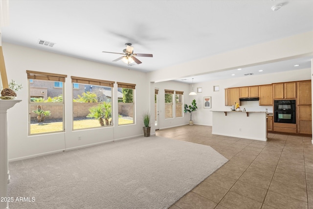 unfurnished living room featuring ceiling fan, light tile patterned floors, visible vents, and baseboards