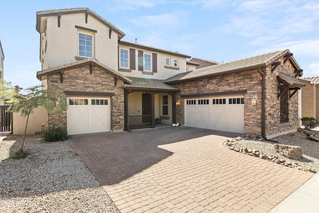 view of front of property with stone siding, a tile roof, decorative driveway, and stucco siding