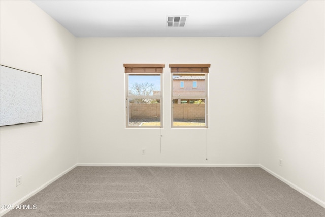 carpeted empty room featuring visible vents and baseboards