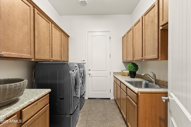 clothes washing area featuring cabinet space, a sink, washer and clothes dryer, and light tile patterned floors