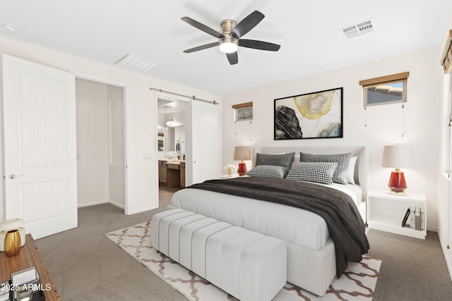 bedroom featuring a barn door, visible vents, and carpet flooring