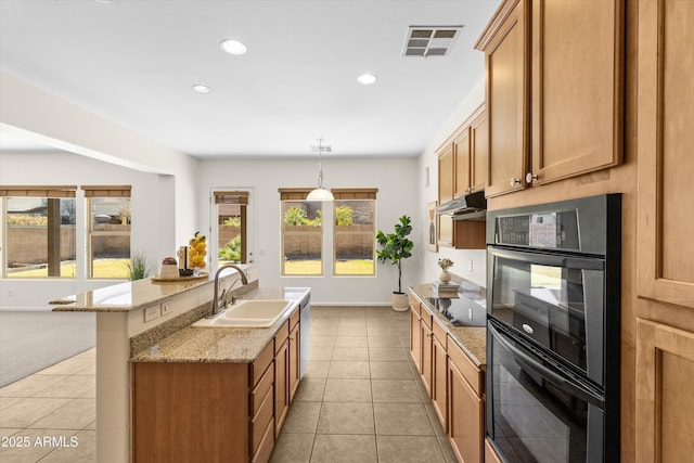 kitchen featuring a kitchen island with sink, under cabinet range hood, a sink, visible vents, and black appliances