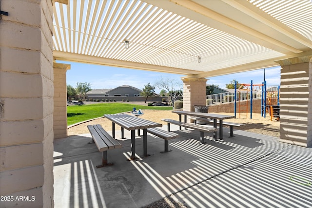 view of property's community featuring a yard, a playground, fence, and a patio