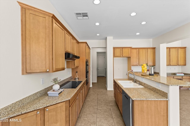 kitchen featuring visible vents, an island with sink, under cabinet range hood, black appliances, and a sink