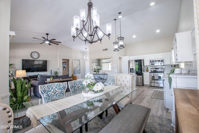 dining room with visible vents, high vaulted ceiling, ceiling fan with notable chandelier, light wood finished floors, and recessed lighting