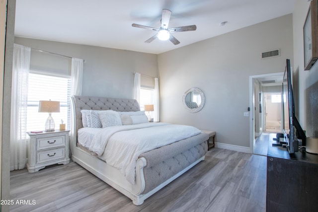 bedroom featuring ceiling fan, visible vents, baseboards, lofted ceiling, and light wood-style flooring