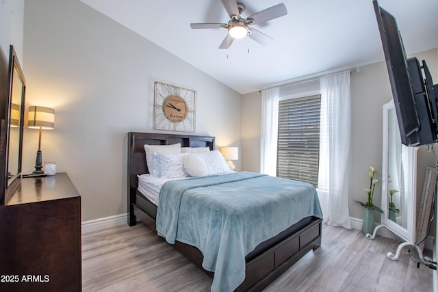 bedroom featuring baseboards, a ceiling fan, light wood finished floors, and lofted ceiling