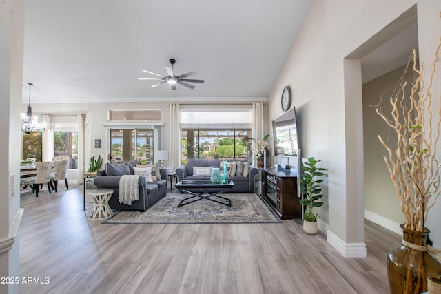 living room with baseboards, ceiling fan with notable chandelier, and wood finished floors