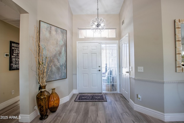 entryway featuring a chandelier, wood finished floors, and a wealth of natural light
