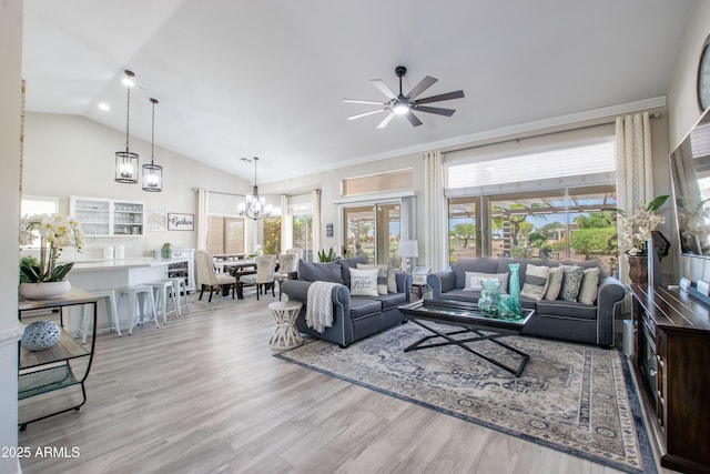 living area with high vaulted ceiling, ceiling fan with notable chandelier, and light wood-style floors