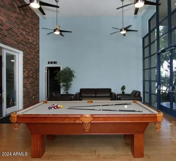 recreation room featuring ceiling fan, hardwood / wood-style flooring, brick wall, and billiards