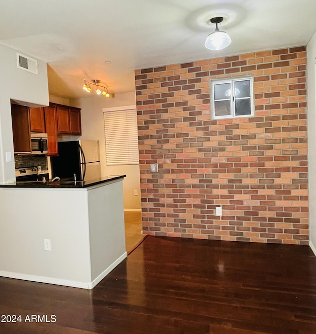 kitchen featuring range, dark hardwood / wood-style floors, decorative backsplash, and fridge